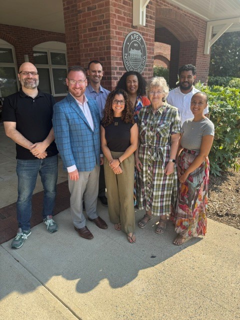 Peak City Land Trust board members with Town of Apex staff partners in front of the Apex Town Hall seal